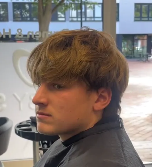 Vorher: herausgewachsenes, glattes Deckhaar in Dunkelblond fällt in die Stirn, Seitenansicht.