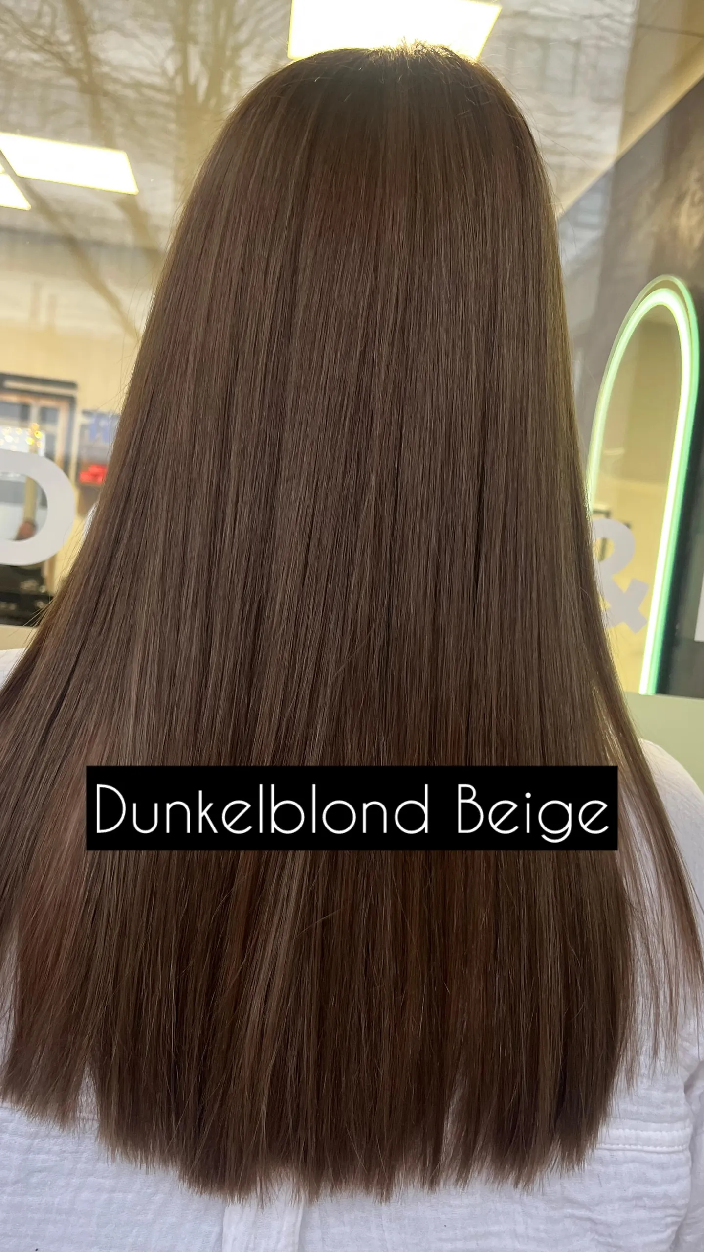Lange, glatt geföhnte Längen in beigem Dunkelblond, von hinten; unten steht die eingeblendete Bildunterschrift „Dunkelblond Beige“.
