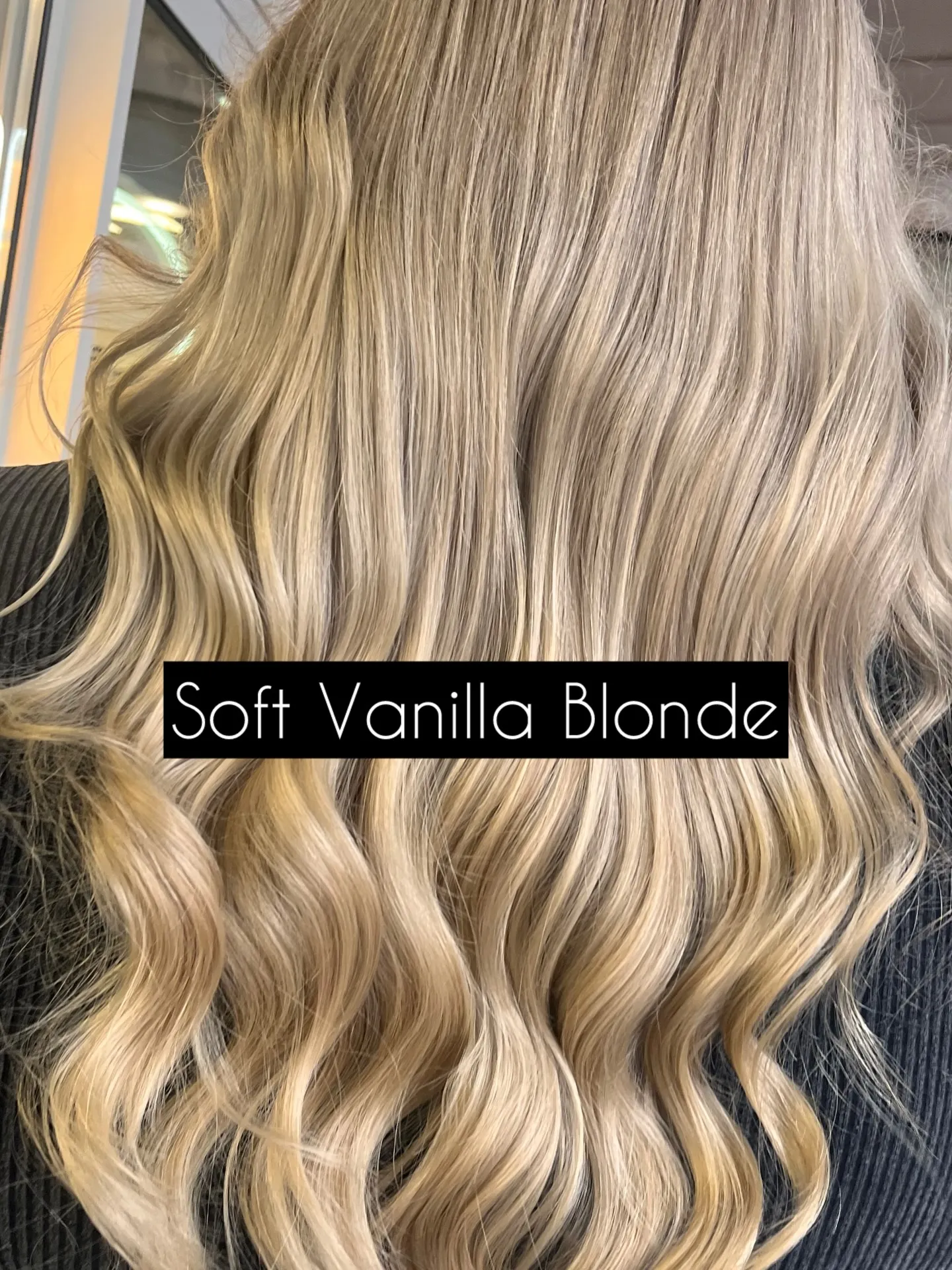 Lange, gleichmäßig gelegte Wellen in hellem Vanilleblond, von hinten; unten steht die eingeblendete Bildunterschrift „Soft Vanilla Blonde“.